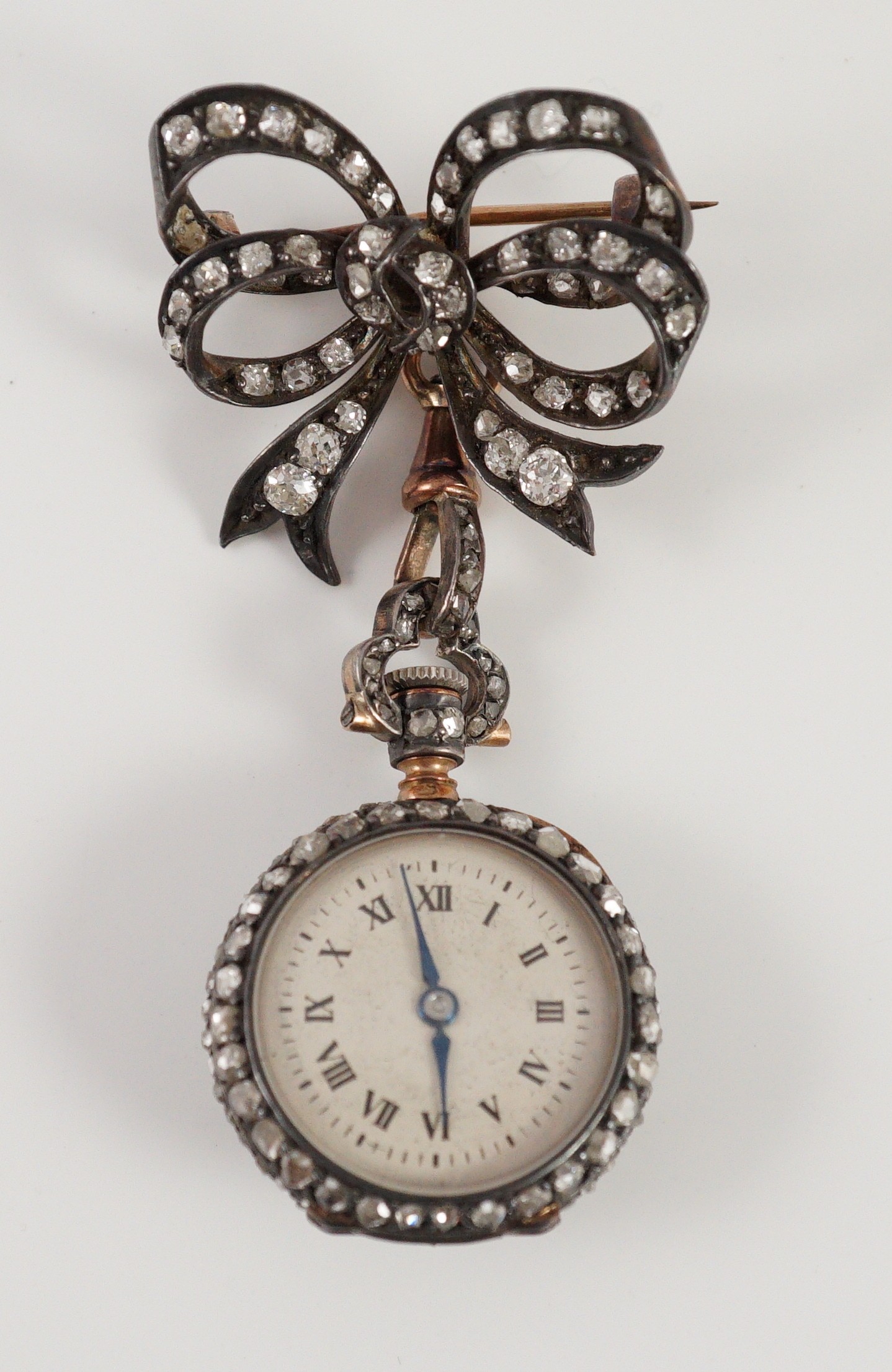 A late 19th century/early 20th century French 18ct gold and rose cut diamond encrusted fob lapel watch, on a rose cut diamond set ribbon bow suspension brooch